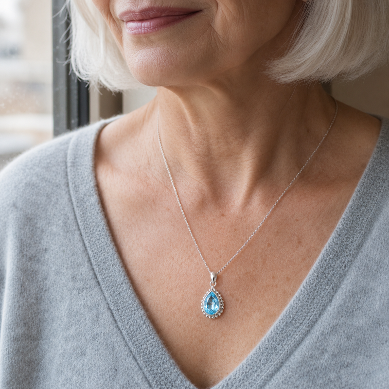 Zilveren hanger met druppelvormig in kraalrand gezette edelsteen - 925 zilver - 9 x 7 mm · Blauwe Topaas · gedragen · steen:blauwe-topaas