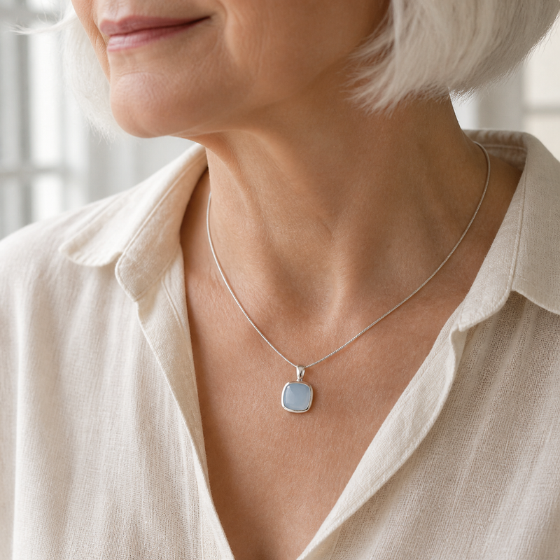 Zilveren hanger met kussen in kap gezette edelsteen · Chalcedoon · gedragen · steen:chalcedoon