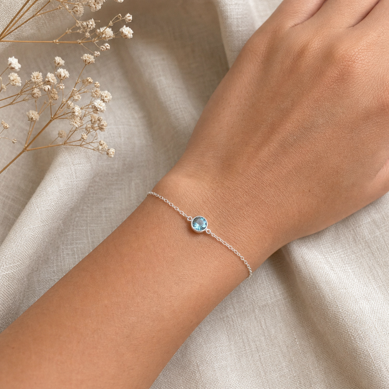 Zilveren armband met rond glad in kap gezette edelstenen · Blauwe Topaas · flatlay · steen:blauwe-topaas