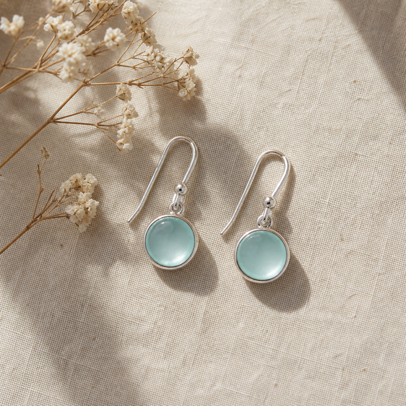 Zilveren oorhangers met rond gladgeslepen in kap gezette edelstenen · Chalcedoon · flatlay · steen:chalcedoon