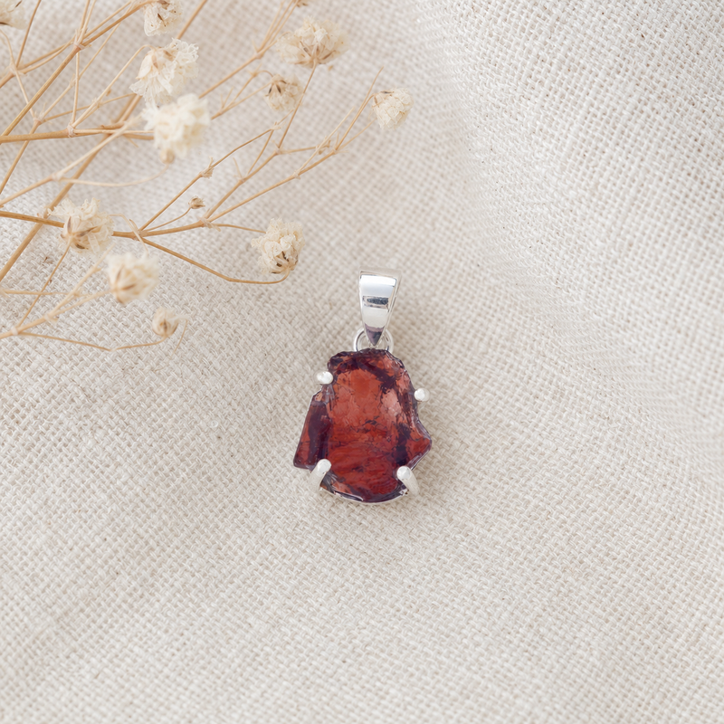 Zilveren hanger met ruwe in klauw gezette edelsteen · Granaat · flatlay · steen:granaat