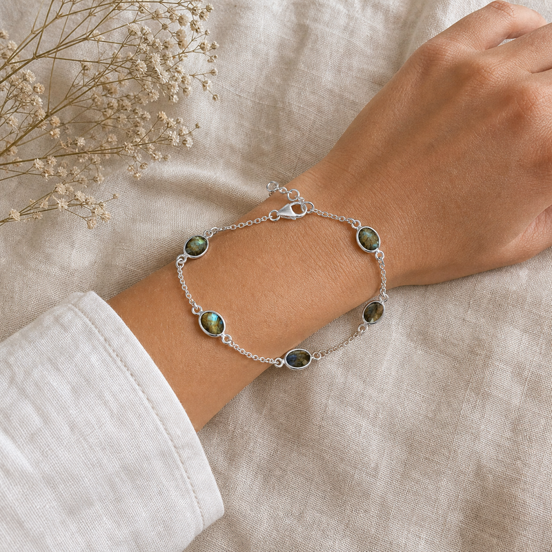 Zilveren armband met ovaal gefacetteerd in kap gezette edelstenen · Labradoriet · flatlay · steen:labradoriet