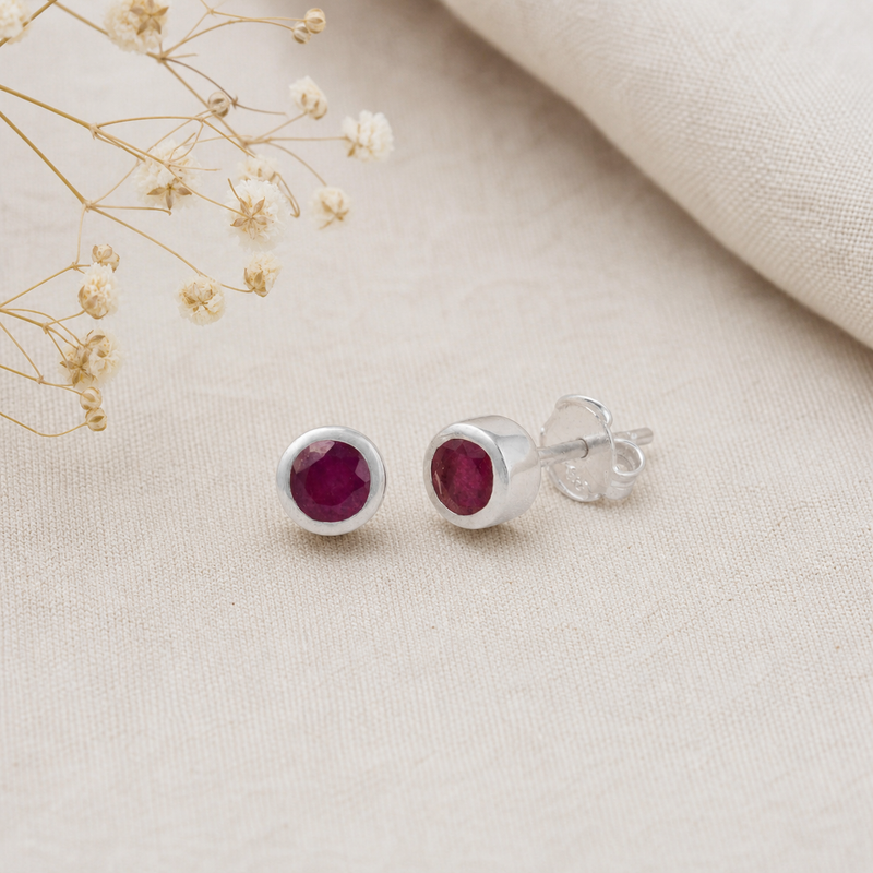 Zilveren oorknopjes met rond glad in kap gezette edelstenen · Robijn · flatlay · steen:robijn