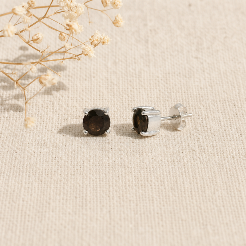 Zilveren oorknopjes met rond gefacetteerde in klauwzetting gezette edelstenen · Rookkwarts · flatlay · steen:rookkwarts