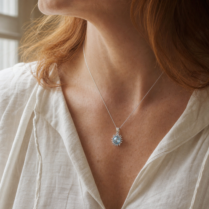 Zilveren hanger met rond gefacetteerd in bolletjeszetting edelsteen · Blauwe Topaas · gedragen · steen:blauwe-topaas