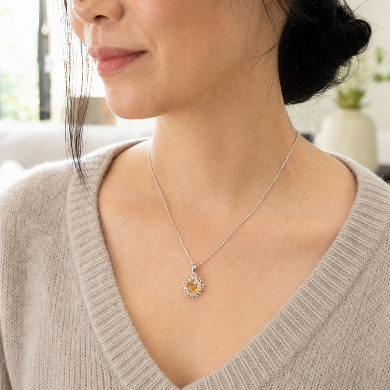 Zilveren hanger met rond gefacetteerd in bolletjeszetting edelsteen · Citrien · gedragen close-up · steen:citrien