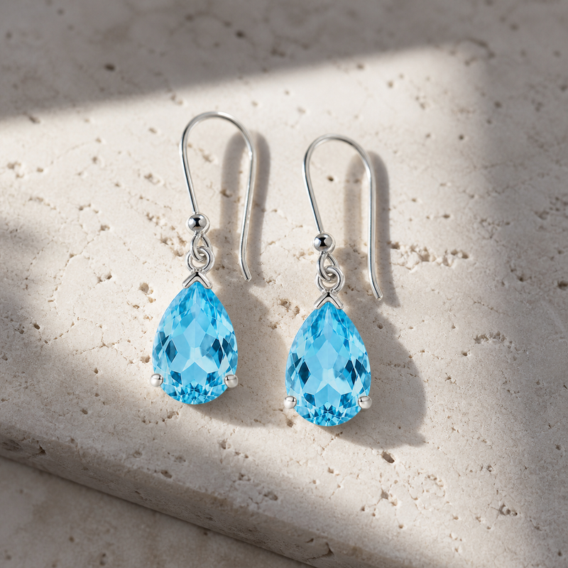 Zilveren oorhangers met druppelvormig in klauwzetting gezette edelstenen · Blauwe Topaas · sfeerbeeld · steen:blauwe-topaas