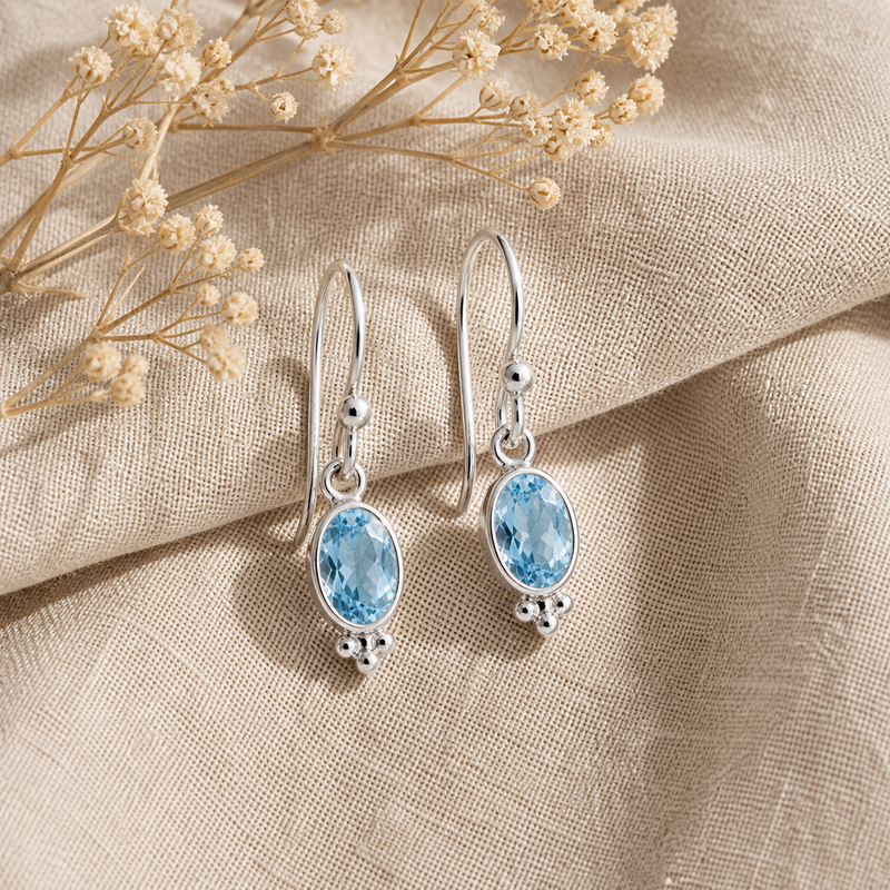 Zilveren oorhangers met ovaal in kap gezette edelsteen - 925 zilver - 20 x 6 mm · Blauwe Topaas · sfeerbeeld · steen:blauwe-topaas