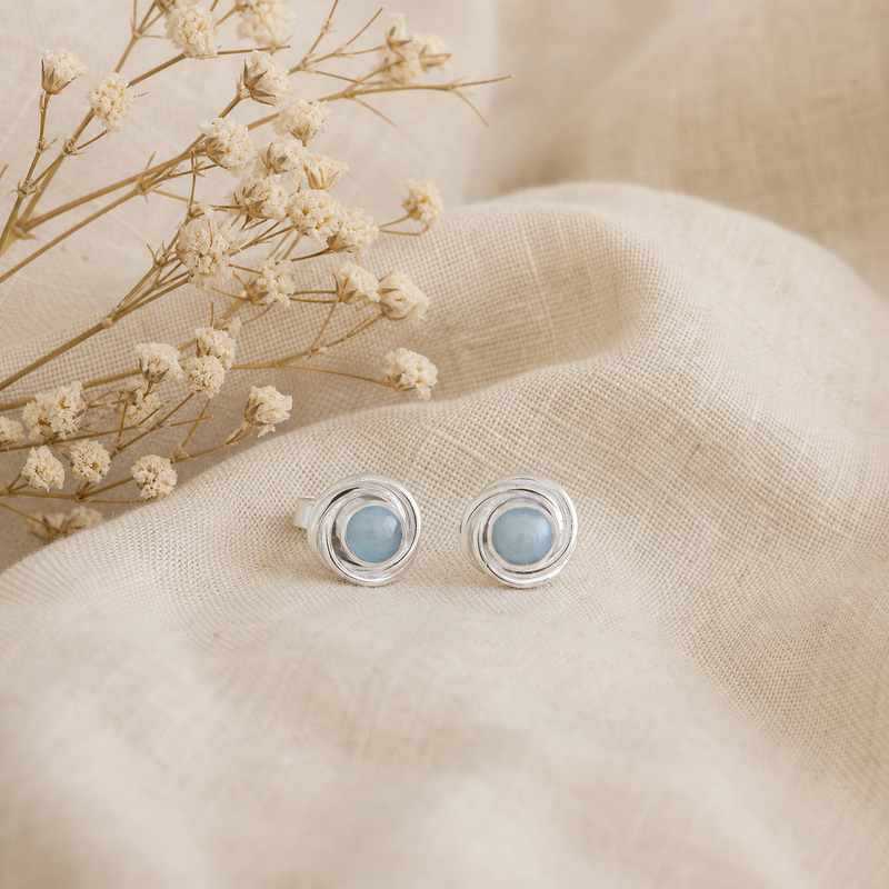 Zilveren oorknopjes met spiraalvormig gezette rond gefacetteerde edelstenen · Chalcedoon · flatlay · steen:chalcedoon