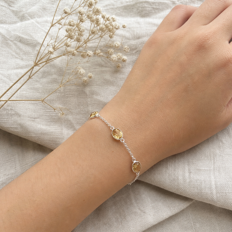 Zilveren armband met ovaal gefacetteerd in kap gezette edelstenen · Citrien · flatlay · steen:citrien