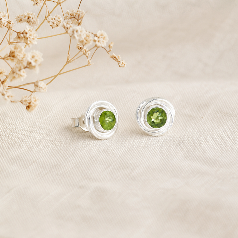 Zilveren oorknopjes met spiraalvormig gezette rond gefacetteerde edelstenen · Peridoot · flatlay · steen:peridoot