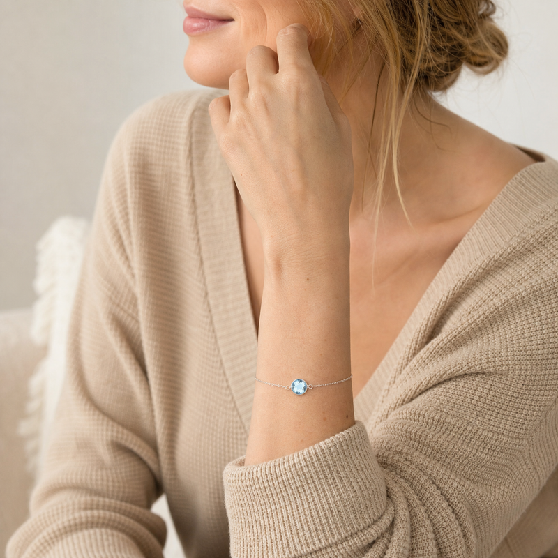 Zilveren armband met rond glad in kap gezette edelstenen · Blauwe Topaas · gedragen close-up · steen:blauwe-topaas